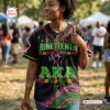 Woman wearing Soror Monique Juneteenth AKA Black History Month Baseball Jersey at outdoor event.