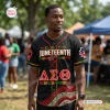 Man wearing a Soror Monique Juneteenth Black History Month Baseball Jersey outdoors in a park.