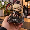 Hand holding a Soul Eater Maka Albarn collectible figure on a detailed cemetery base holding a large scythe.