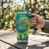 Hand holding a Sprite 68th Anniversary YETI Tumbler Cup with tie dye pattern on a wooden table.