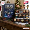 Front view of the Star Trek Christmas 2026 Advent Calendar box alongside collectible figures on a tiered shelf.