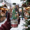 Front view of a Star Wars Christmas Tree 40oz Tumbler Cup held in gloved hands outdoors.