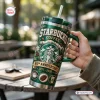 Hand holding a green Starbucks 55th Anniversary 1971-2026 Tumbler with straw outdoors.