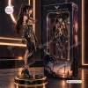 Side view of a Stellar Blade Eve vinyl figure statue standing on a lit circular base beside its packaging box.