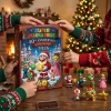 Front view of hands opening Super Mario Bros. 40th Anniversary Mushroom Kingdom 2026 Advent Calendar near holiday tree.