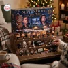 Front view of Supernatural Christmas Advent Calendar 2026 box and miniature figures arranged on wooden steps.