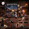 Front view of the Supernatural Hunters Road Advent Calendar 2026 box surrounded by miniature figurines and themed props on a wooden table.