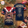 Front and back view of the Sydney Roosters 2026 NRL Premiership Shirt on a wooden surface with eucalyptus leaves.