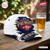 Front view of Sydney Roosters NRL Premiers 2026 Cap resting on a wooden table beside a glass of beer.