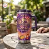Front view of the Taco Bell 65th Anniversary Handle Tumbler featuring purple and orange tie-dye graphics and a straw.