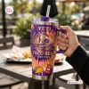 Hand holding a Taco Bell 65th Anniversary Handle Tumbler with purple and orange flames.
