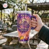 Hand holding Taco Bell 65th Anniversary Handle Tumbler with purple and orange tie dye pattern outdoors.