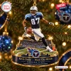 Close-up of a Tennessee Titans player figurine running on a miniature football field Christmas ornament.