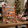 Lifestyle view of a Tennessee Volunteers advent calendar with collectible figurines arranged on a wooden table near a Christmas tree.