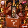 Couple unboxing a Texas Longhorns Stadium Solar Garden Light from a branded orange package.