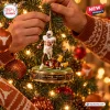 Closeup of hands hanging a Texas Longhorns Vince Young 4th and 5 Ornament on a lit Christmas tree.