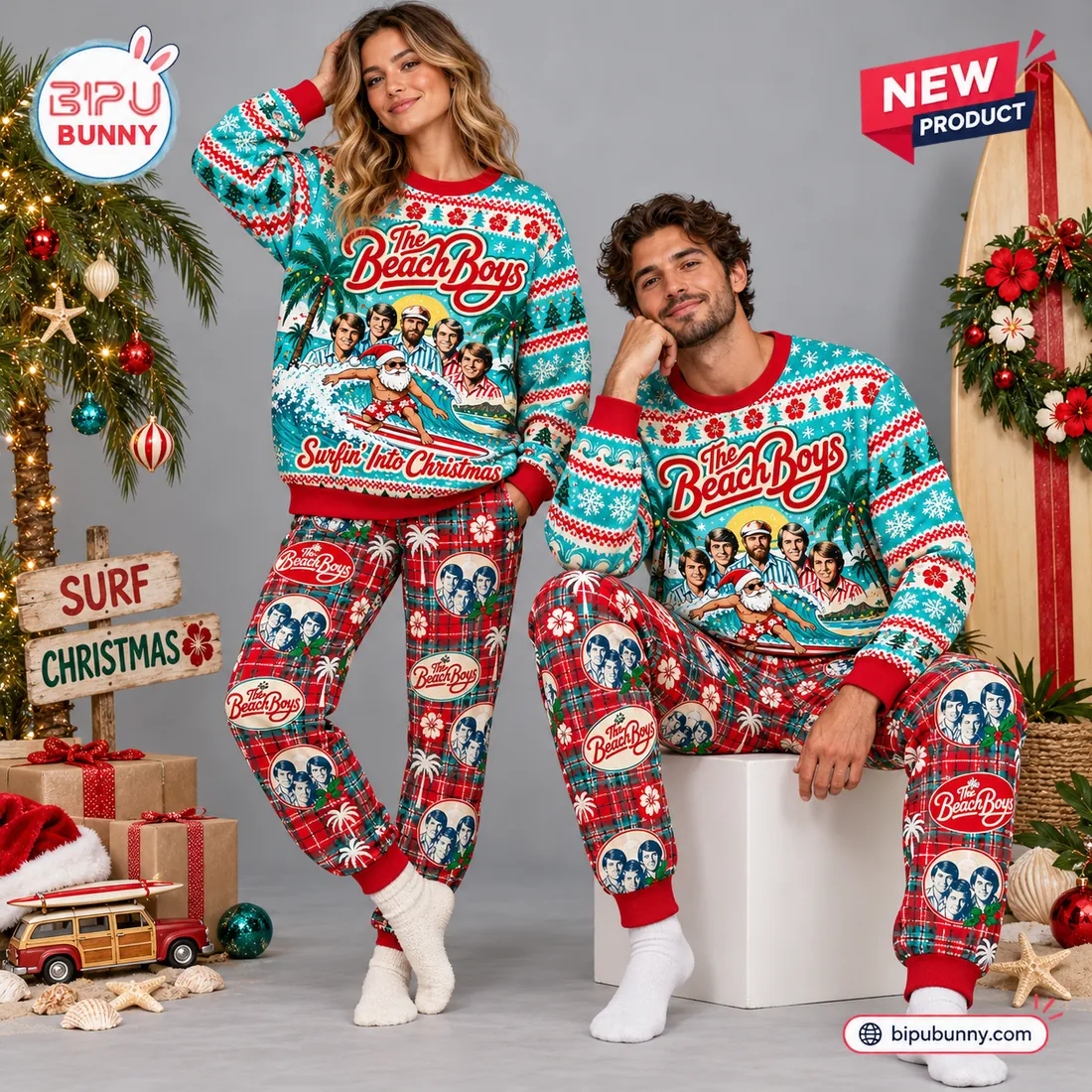Couple wearing matching The Beach Boys Christmas sweater and jogger sets with surfboard holiday display