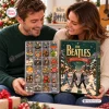 A smiling couple holding The Beatles Christmas Advent Calendar Box Ornament with small charms visible inside.