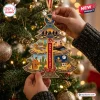 Close-up of hands hanging The Eagles 55th Anniversary Christmas Ornament on a tree.