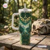 Front view of The Legend of Zelda 40th Anniversary Tumbler featuring a green forest design and gold crest on a wooden table.