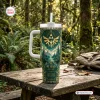 Front view of The Legend of Zelda 40th Anniversary Tumbler with a green forest design and gold emblem on a wooden table.