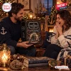 Man and woman holding The Leviathan Black Spiced Rum 2026 Advent Calendar in a cozy room.