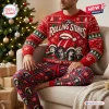 Front view of a person wearing The Rolling Stones 2026 Christmas Sweater and Pants Set seated by a lit tree.