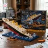 Assembled Titanic Sinking Ship Model Building Block Set tilted on a blue base next to its packaging box.