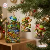 Three ninja turtle figurines hanging on a decorated pine tree branch with a box below.