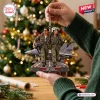 Closeup of hands holding a Top Gun Maverick aircraft Christmas ornament featuring pilots in flight suits.