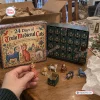 Front view of an Ugly Medieval Cats Advent Calendar with open boxes and small feline figurines displayed on a table.