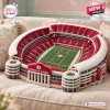 High angle view of a University of Alabama Plush Stadium Pillow resting on a beige couch.