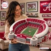 Woman holding the University of Alabama Plush Stadium Pillow featuring a detailed football field and seating bowl.
