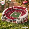 Angled view of University of Alabama Plush Stadium Pillow sitting on outdoor grass.