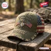 Front view of an olive green US Marine Veteran embroidered baseball cap resting on a wooden surface.