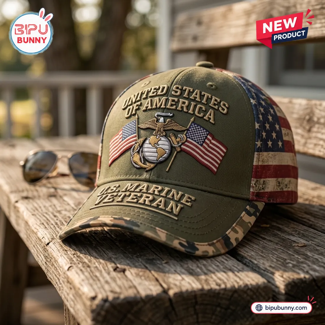 Side angle of the US Marine Veteran Embroidered Baseball Cap resting on a wooden bench beside aviator sunglasses
