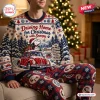 Front view of a person wearing a Volkswagen x Snoopy Christmas sweater and jogger set by a lit tree.