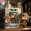 Front view of West Virginia Mountaineers vinyl figure beside its box on a wooden shelf.