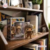 Front view of a West Virginia Mountaineers vinyl figure displayed beside its packaging box on a wooden bookshelf.