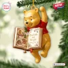 Close-up of a hanging Christmas ornament featuring a yellow bear holding an open book reading Bookish and Bright.