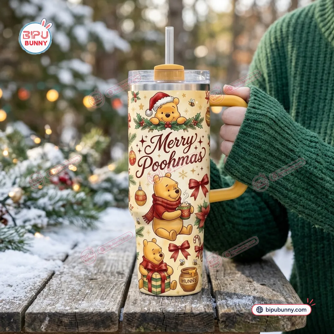 Winnie the Pooh Christmas 40 oz Tumbler held outdoors by its honey-gold handle on a snowy wooden table