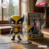 Front view of the Wolverine Weapon X vinyl figure next to its illustrated packaging box on a wooden table.