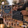 Person opening a Wu-Tang Clan 35th Anniversary Advent Calendar with collectible vinyl figures displayed.